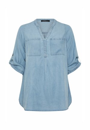 Camicia di jeans azzurra con scollatura a V, due tasche frontali e maniche arrotolate. Il tessuto ha una consistenza morbida e una vestibilità rilassata.