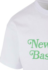 Hvid bomulds t-shirt med et grønt grafisk teksttryk, der står "New Basics", med en klassisk rund halsudskæring og korte ærmer.