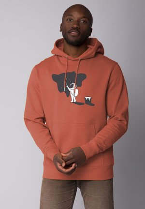 Roestkleurige hoodie van zacht materiaal, met een grafisch ontwerp van een astronaut die een sterrenhemel schildert, met een verfemmer.