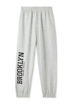 Pantaloni grigi in felpa con vita elastica. Presentano la scritta stampata nera "BROOKLYN NEW YORK ATHLETICS" lungo la gamba sinistra. Vestibilità standard a gamba affusolata.
