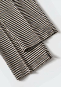 Tissu à motifs présentant un design pied-de-poule dans des nuances de beige, marron et marine. La texture semble tissée et lisse.