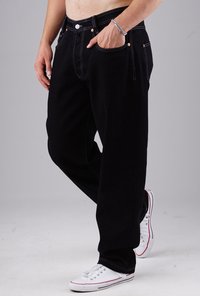 Black denim jeans with contrasting white stitching, straight-leg design, five-pocket style, and metal hardware details. Worn with white sneakers.