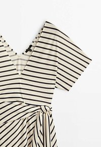 Robe rayée crème et marine, avec un décolleté en V, des manches courtes et un détail ceinturé à la taille. Tissu doux avec une texture lisse.