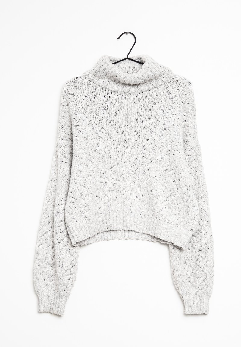 Pull à col roulé en maille épaisse gris clair avec de longues manches ballon suspendu sur un cintre noir sur fond blanc.