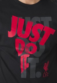 Svart bomull t-skjorte med fet rød og grå grafisk tekst "JUST DO IT." med Liverpool FC-logoen nederst til høyre.