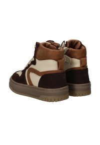 Een paar bruine, crèmekleurige en tan hoge sneakers met dikke zolen en zijritsen, van achteren weergegeven op een witte achtergrond.