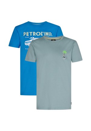 Dos camisetas de algodón apiladas. Una es azul con texto gráfico blanco y un diseño de coche; la otra es verde claro con un bordado de una palmera y una bicicleta.