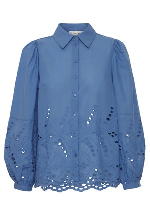 Gaiši zila blūze ar norādītu apkakli, pogu aizdari un izšūti izgriezti ziedu raksti pie apakšmalas un puffiem piedurknēm.