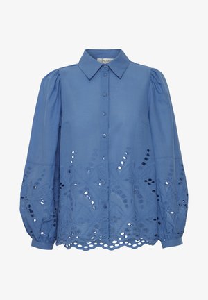 Gaiši zila blūze ar norādītu apkakli, pogu aizdari un izšūti izgriezti ziedu raksti pie apakšmalas un puffiem piedurknēm.