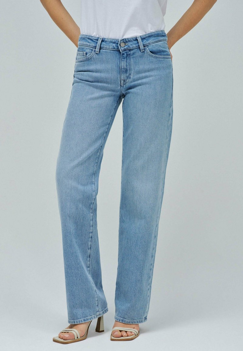 Jeans de pierna recta en azul claro, fabricados en tela de mezclilla, que presentan un diseño clásico de cinco bolsillos y un sencillo herraje metálico.