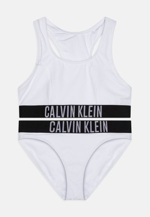Witte bikini set met een racerback top en bijpassende bottoms. Zwarte elastische banden met "CALVIN KLEIN" in het grijs, gladde stof textuur.