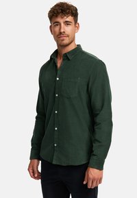 Grüne Cordhemd mit langen Ärmeln, Knopfverschluss und Brusttasche. Verfügt über einen strukturierten Stoff und ein klassisches Kragen-design.
