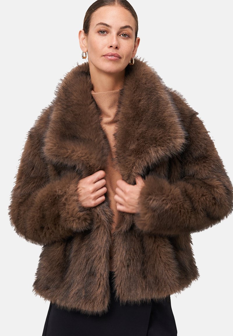Manteau en fausse fourrure marron avec un large col, un design court et des manches longues. Texture douce, apparence touffue et ajustement snug autour du corps.