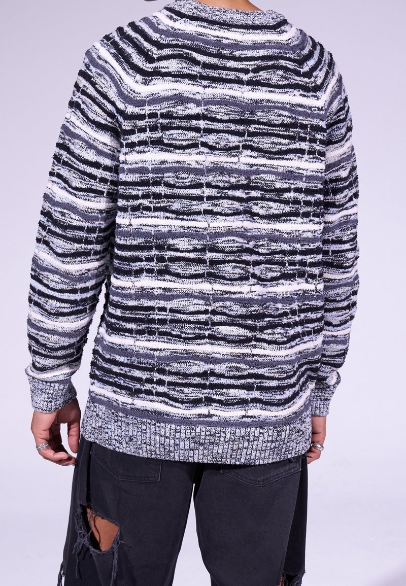 Strickpullover mit strukturiertem, gestreiftem Muster in Schwarz und Weiß. Verfügt über einen Rundhalsausschnitt und gerippte Bündchen, angepasst für einen lässigen Schnitt.