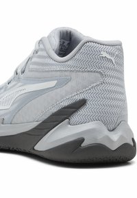 Chaussure de sport grise avec un dessus en tissu texturé, accents blancs et une semelle intermédiaire grise épaisse présentant des motifs en zigzag. Numéro de modèle visible à l'intérieur.