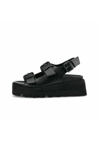 Sandalias de plataforma negras hechas de material sintético, con tres correas ajustables con hebillas y un diseño de suela ondulada.