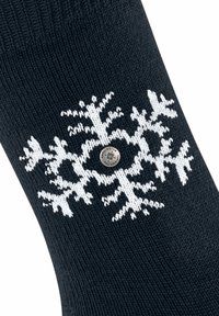 Czarna wełniana skarpeta z białym wzorem płatka śniegu i srebrnym logo. Tekstura jest gładka, z żebrowanym wykończeniem na górze.