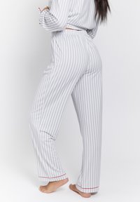 Gray and white striped pajama pants with a relaxed fit, elastic waistband, and red accent at the hem, featuring a smooth cotton fabric.