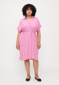 Ροζ και λευκό ριγέ ντύσιμο πουκαμίσα με κοντά μανίκια, κουμπάκι στο μπροστινό μέρος και ζώνη στη μέση. Λείο ύφασμα με χαλαρή εφαρμογή.