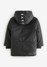Veste noire imperméable avec capuche, présentant un logo au dos et un design de panneaux contrastés. Texture lisse avec une coupe décontractée.