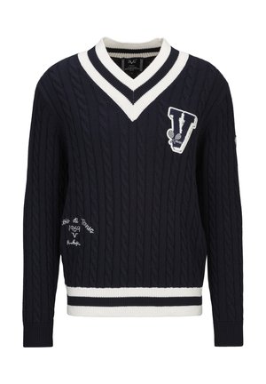 Marineblauwe kabelgebreide trui met een witte en zwarte gestreepte V-hals en zoom, voorzien van een grote "V" patch en geborduurde tekst.
