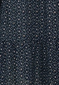 Navy blue fabric featuring a swirling floral pattern in pink, white, and light blue, with a gathered hem detail for added texture.
