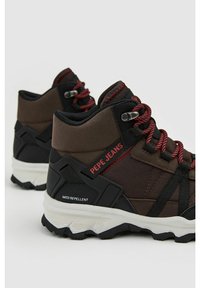 Zapatos de tobillo impermeables marrones con cordones rojos, cuello acolchado y detalles en negro. Presentan una suela texturizada y la marca "PEPE JEANS".
