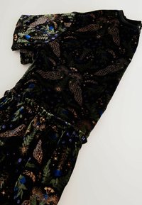 Melnas samta kleitas ar sarežģītiem ziedu un debesu rakstiem zaļā, zilā un vara krāsā; elastīga josta ar savākta svārku detaļu.