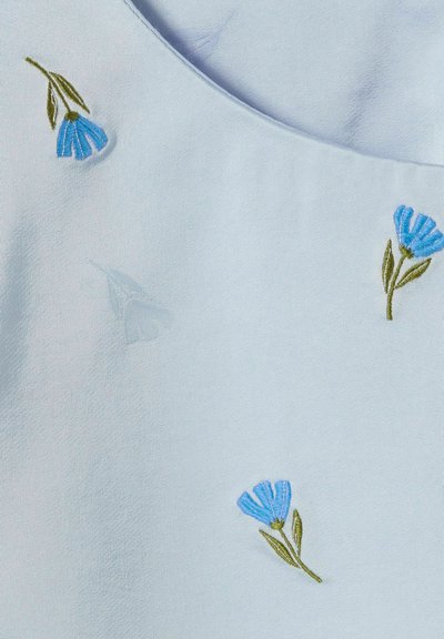 Tessuto azzurro chiaro con delicato ricamo di fiori blu con steli verdi, su uno sfondo liscio e strutturato.