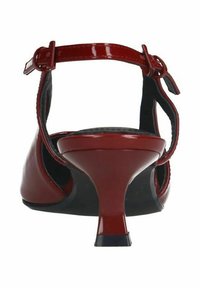 Escarpin en cuir verni rouge, avec une bride à la cheville, présentant un bout pointu et un talon fin, texture lisse et accents de semelle noire.