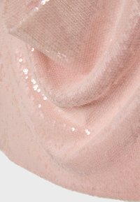 Tissu rose doux avec une texture en maille fine, drapé de petits sequins brillants dispersés captant la lumière.