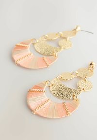 Orecchini in filo d'oro e pesca presentano accenti dorati circolari, superfici testurizzate e un design stratificato con dettagli in fine catena.