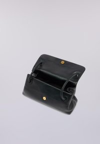 Černá kožená kabelka s zaoblenými hranami, vybavená zlatým kruhovým zapínáním a šňůrkovými uchy. Otevřená, aby ukázala prostorný interiér.