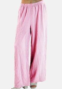 Pantalon large rose clair en tissu texturé avec une finition froissée ; taille élastique et silhouette fluide.