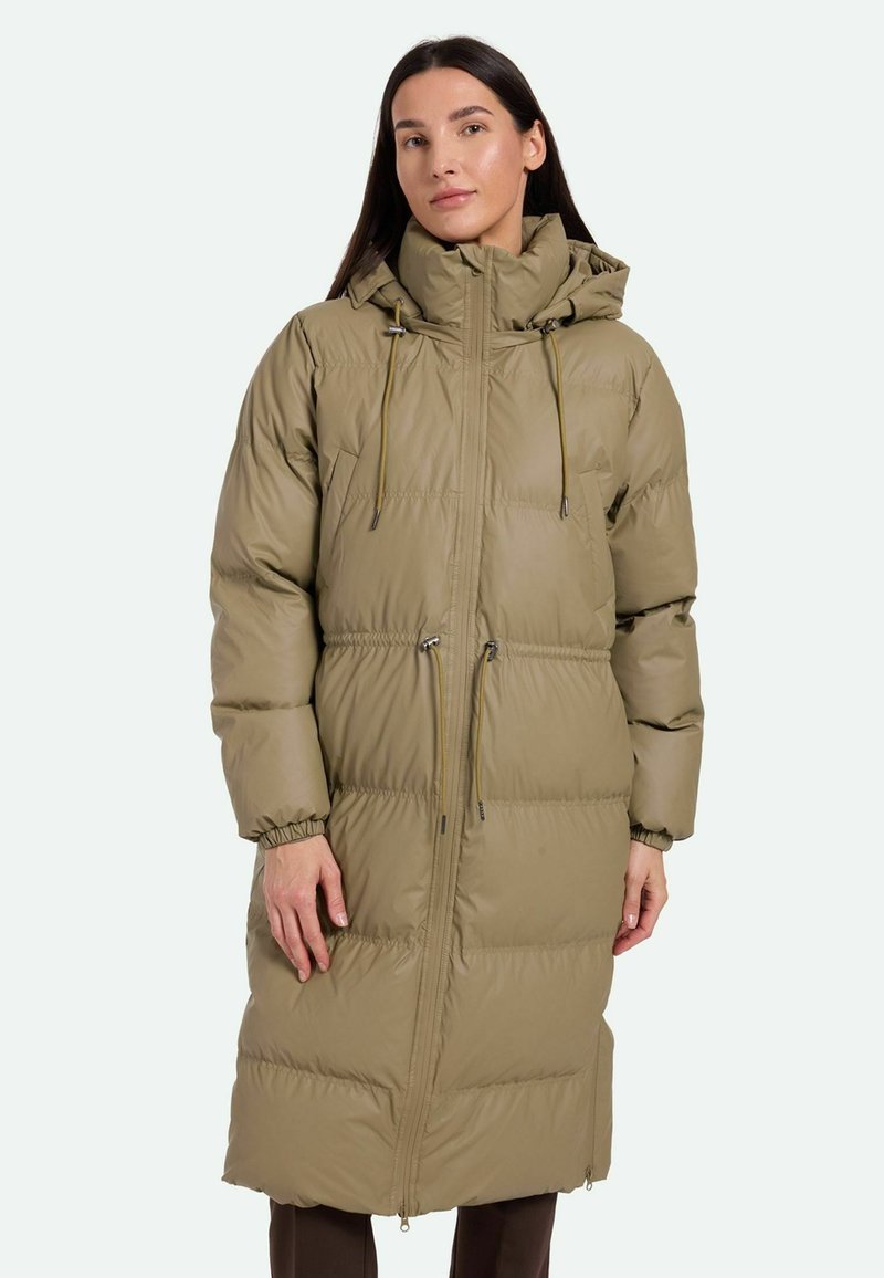 Parka larga y acolchada de color verde oliva con un alto cuello, cordones ajustables, cierre de cremallera en la parte delantera y puños elásticos. Textura suave y diseño cálido.