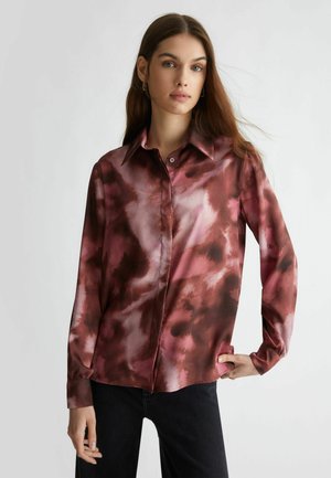 Camicia con maniche lunghe ebottoni, caratterizzata da una consistenza fluida e simile alla seta. Presenta un motivo astratto rosso e rosa, colletto a punta e polsino a un bottone.