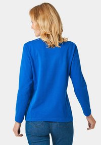 Blaues Langarmshirt aus Baumwolle, mit einem schlichten Design, runder Halslinie und lockerer Passform. Glatte Textur ohne Muster.