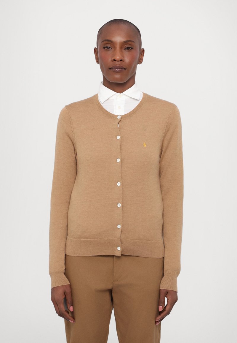Light brown cardigan sweater with a round neckline, button closure, and a small yellow logo on the left chest. Long sleeves, ribbed cuffs.