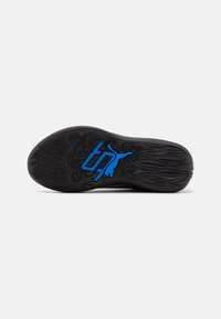 Semelle de chaussure noire en caoutchouc avec des motifs texturés et un détail de logo bleu. Le design présente des lignes tourbillonnantes et un motif de semelle prononcé.