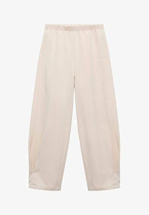 Hosen mit elastischem Bund in Hellbeige. Aus weichem Stoff gefertigt, mit Seitentaschen und einem entspannten, lockeren Schnitt. An den Knöcheln schmal zulaufend.