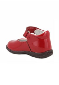 Scarpa Mary Jane in vernice rossa con cinturino in velcro, punta arrotondata e suola in gomma marrone. Texture liscia e design semplice.