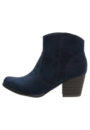 Marineblauwe suède enkellaars met gestapelde blokhak, afgeronde neus en decoratieve stiksels aan de zijkant en voorkant.