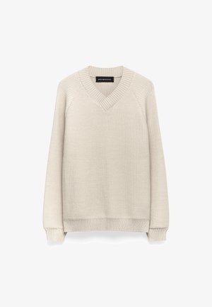 Pull en V de couleur beige clair, texture tricotée avec des accents côtelés au niveau de l'encolure et de l'ourlet, manches longues, coupe classique. Sans motifs ni logos.