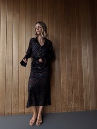 Μαύρο φόρεμα με πουά, διαθέτει αέρινο σχέδιο, μακριά μανίκια και μήκος μέχρι τη μέση της γάμπας. Το ύφασμα είναι απαλό με πολύχρωμες κουκκίδες και ζώνη.