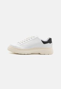 Hvite lær sneakers med teksturert overflate, kontrastfarget svart h�æl, rund tå og tykk beige gummi såle. Har snøring og logo.