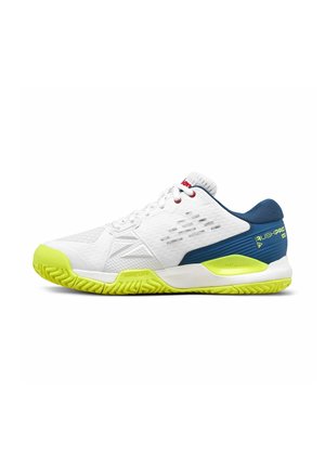Scarpa sportiva bianca con tallone blu, suola gialla neon e lacci, progettata per lo sport con una suola strutturata e materiale superiore traspirante.