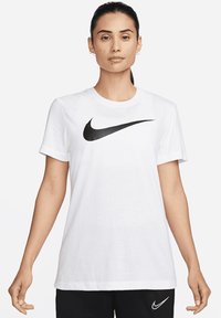 Weißes Baumwoll-T-Shirt mit kurzen Ärmeln, das auf der Vorderseite ein auffälliges schwarzes Nike-Logo trägt. Glatte Textur, klassische runde Ausschnittform.