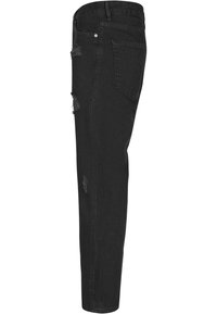 Mustat farkut slim fit -mallia, joissa on kulutettuja yksityiskohtia edessä, viisi taskua sekä klassinen nappi- ja vetoketjukiinnitys.