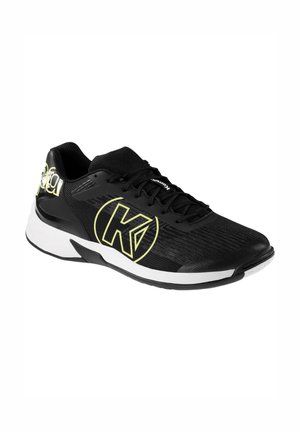 Zwarte sportieve schoen met een bovenwerk van mesh, voorzien van een groot geel logo, een witte zool met zwarte accenten en een gestructureerde afwerking.