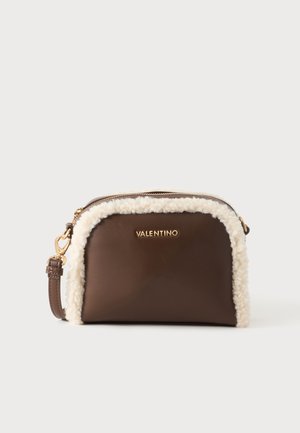 Καφέ τσάντα Valentino crossbody με χρυσό λογότυπο, λευκή επένδυση shearling, χρυσό φερμουάρ και ρυθμιζόμενο λουράκι σε απλό φόντο.